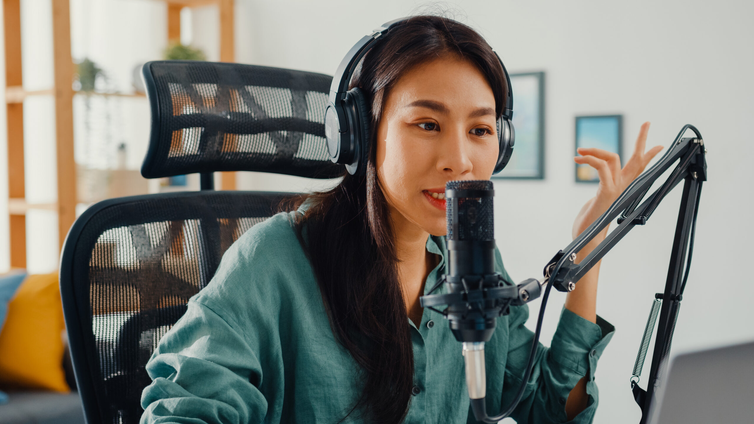 Happy asia girl record a podcast on her laptop computer with hea Happy asia girl record a podcast on her laptop computer with headphones and microphone talk with audience at her room. Female podcaster make audio podcast from her home studio, Stay at house concept.